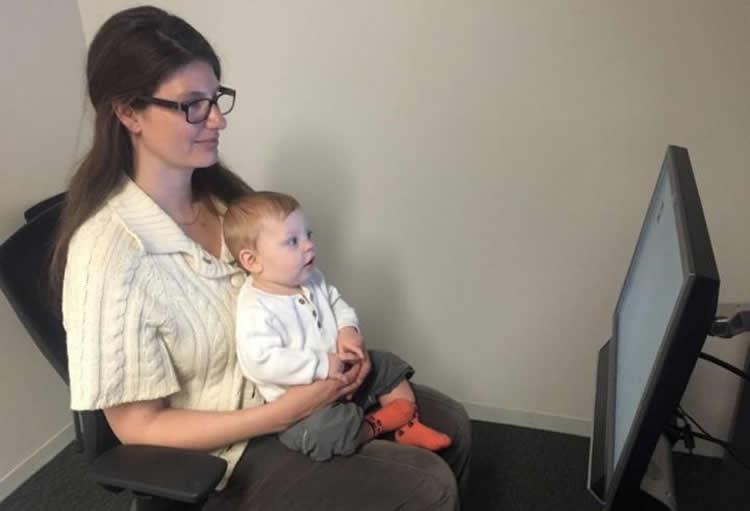 A little research volunteer gazes at the screen, ready to demonstrate some surprising new findings about how babies use context to direct their attention. NeuroscienceNews.com image is credited to Kristen Tummeltshammer.